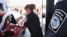 In this June 21, 2005, file photo, U.S. Customs and Border Protection Inspector Maria Arreola checks an electronic ID card at one of two new Secure Electronic Network for Travelers Rapid Inspection lanes at the San Ysidro Port of Entry in San Diego. (AP / Denis Poroy, File)