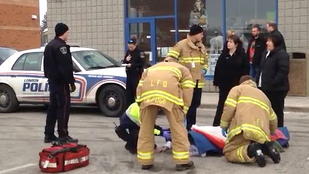 Firefighters treat a man reportedly struck by a fleeing vehicle after a pharmacy robbery in London, Ont. on Friday, Jan. 23, 2015. (Chuck Dickson / CTV London)