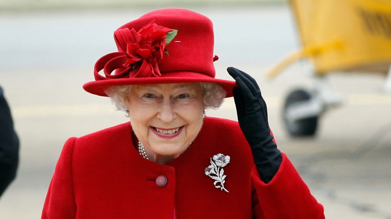 Queen Elizabeth II holds on to her hat in high winds during a visit to RAF Valley, Anglesey, Wales, where her grandson Prince William, is stationed as a search and rescue helicopter pilot Friday April 1, 2011. (AP / Christopher Furlong)