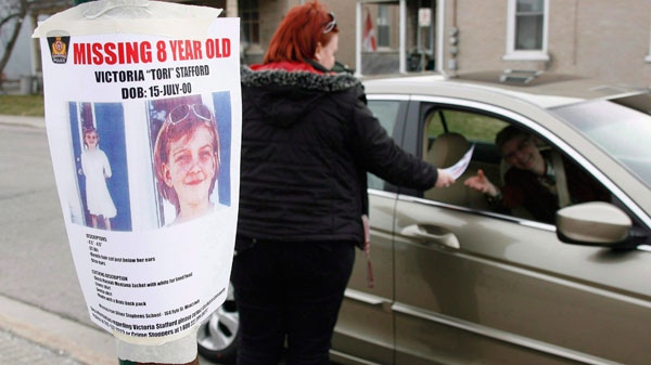 Tiffany Ackers hands out a poster for then missing Victoria Stafford, 8, on a street corner in Woodstock, Ont. on Friday April 10, 2009. (Dave Chidley / THE CANADIAN PRESS)