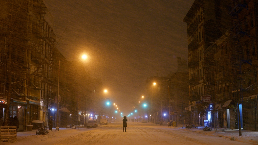 Person stands in East Village during storm