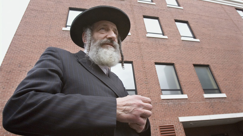 Rabbi Asher Wieder stands in front of a wall of frosted windows at a YMCA in Montreal, Tuesday, Nov. 7, 2006, that are at the heart of a dispute between some Hasidic Jews and people who exercise at the gym.