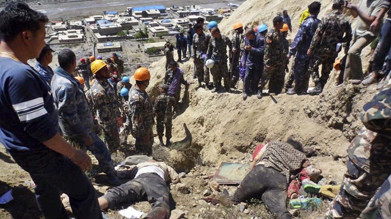 Bodies of victims of plane crash lie on the ground as Nepalese rescue workers inspect the site of the crash near Jomsom, 200 kilometeres northwest of the capital, Katmandu, Nepal