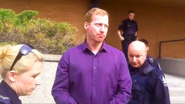 Travis Vader is led out of an Edson courtroom, May 15, where he made his first appearance related to two murder charges.