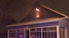 Flames are seen from the second-floor window of a Moose Jaw house early Saturday morning. (Twitter / @MJPolice)