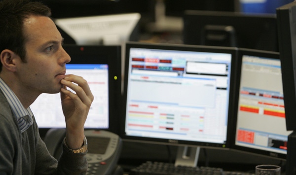 A trader reacts to early market moves on the London Stock Exchange and the FTSE100 index at CMC Markets in London, Monday, Oct. 6, 2008. (AP / Alastair Grant)