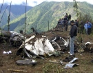 People stand around the wreckage of a Yeti Airlines DeHavilland DHC-6 Twin Otter plane at Lukla airport, about 40 miles (60 kilometers) from Mount Everest, Nepal, Wednesday, Oct. 8, 2008. (AP / Suraj Kunwar)