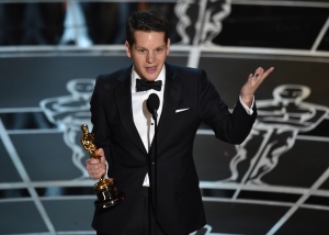 Graham Moore accepts the award for the best adapted screenplay for 'The Imitation Game' at the Oscars on Sunday, Feb. 22, 2015, at the Dolby Theatre in Los Angeles. (Invision / John Shearer)