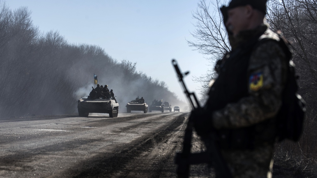 Ukrainian troops ride on armoured vehicles
