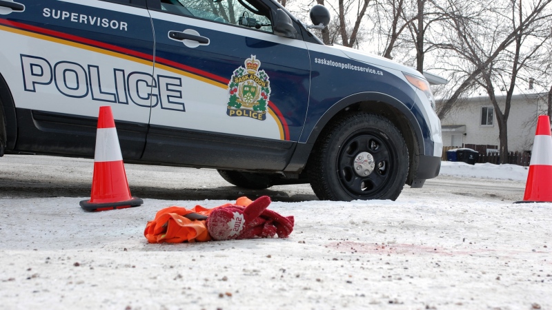 A Saskatoon police cruiser sits at the corner of 33rd Street and Avenue W where a stabbing victim was found Saturday afternoon. Mitts, an article of clothing and blood lie at the scene.
