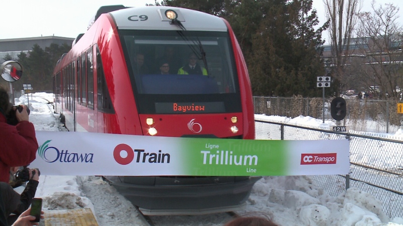 A new train on Ottawa's Trillium Line breaks a ribbon as it arrives at a stop this morning.