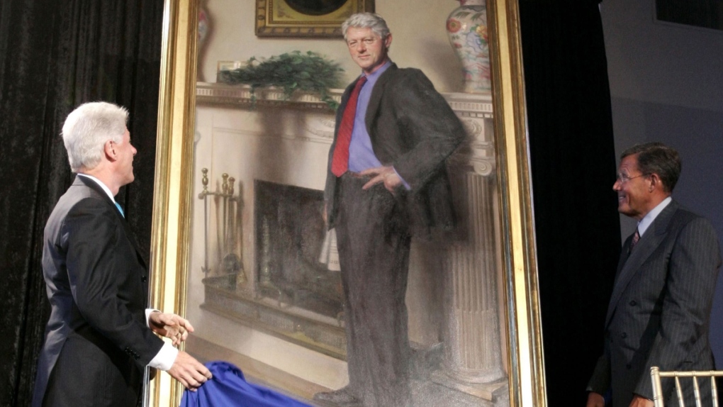 Bill Clinton, left, looking at his portrait