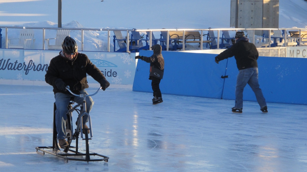 Man rides ice bike on outdoor rink