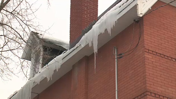 Giant icicles hang from a roof top 