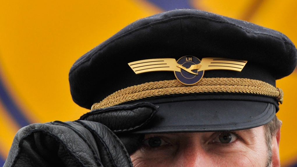 Lufthansa Airlines pilot holds the brim of his cap