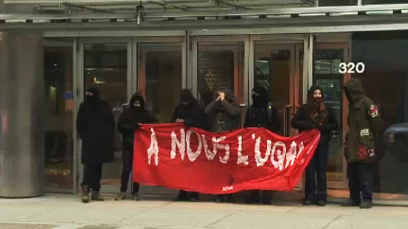 Protesters are seen blocking an entrance to UQAM M