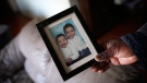Germano Wabafiyebazu holds a baby photo of his two sons Marc, left, and Jean Wabafiyebazu at his home in Ottawa on Wednesday, April 1, 2015. Wabafiyebazu's elder son Jean, 17, was killed Monday, while his younger one, Marc, 15, was arrested in connection with what local media outlets have characterized as a marijuana deal gone wrong. (Cole Burston/THE CANADIAN PRESS)