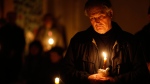 A worshipper holds a candle during the Easter vigil mass in Cathedral-Basilica at the Vilnius, Lithuania on Saturday, April 4, 2015. (AP / Mindaugas Kulbis)