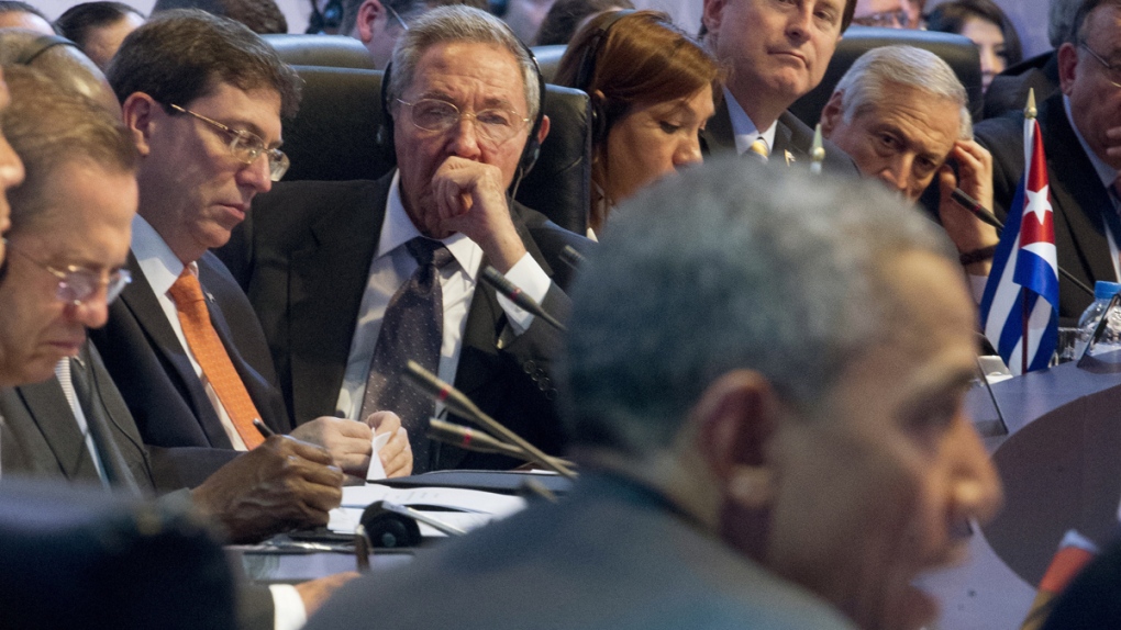 Raul Castro, centre, listens as Obama speaks