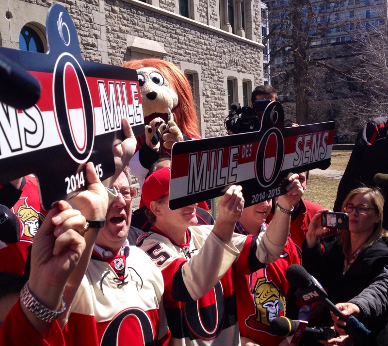 Ottawa Mayor Jim Watson and Senators president Cyril Leeder hold up Sens Mile street signs as Sens Mile on Elgin St. officially opens for the team's playoff run. April 12, 2015.