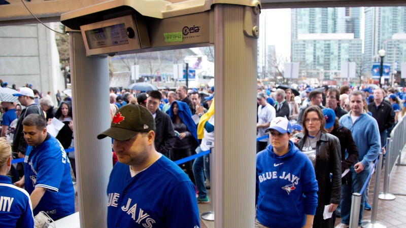 Fans pass through metal detectors ahead of the Toronto Blue Jays home opener in Toronto on Monday, April 13, 2015. (Peter Power / THE CANADIAN PRESS)