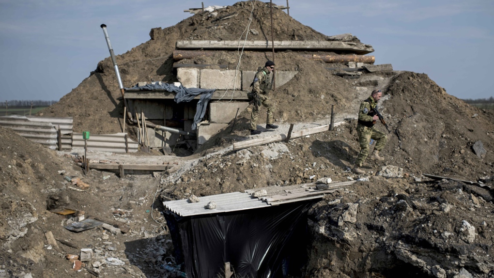 Ukrainian servicemen walk in Lebedynske