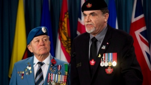 Veterans advocate Ron Clarke, left, listens to Canadian Veterans Advocacy president Mike Blais speak during a press conference, Wednesday, Jan. 28, 2015. (Adrian Wyld / THE CANADIAN PRESS)