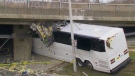 A bus is wedged under an overpass in Toronto on Monday, April 27, 2015. 