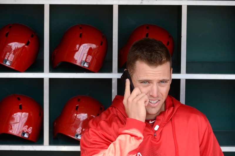 In this April 1, 2013, file photo, Los Angeles Angels outfielder Mike Trout talks on a cell phone in the dugout at Great American Ball Park in Cincinnati. (AP / Michael Keating)