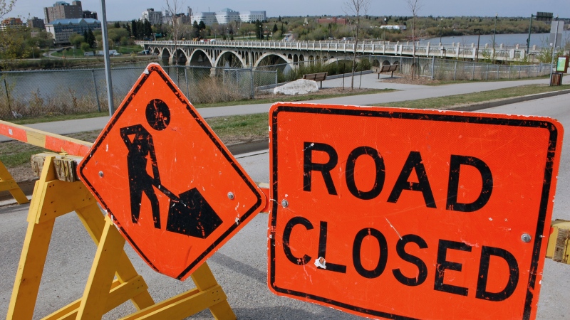 A 'Road Closed' sign sits along Saskatchewan Crescent East, near the top of the University Bridge. The bridge is closed until the end of August.