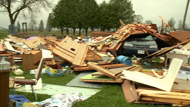 A microburst flipped the Quinn family's mobile home on top of the car and scattered their belongings.
