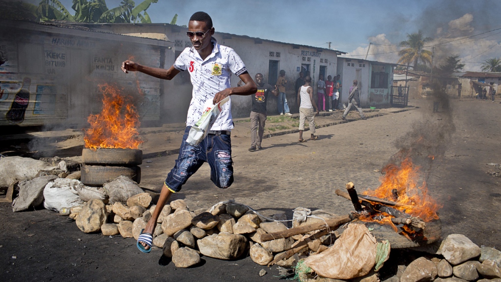 A civilian at a burning barricade in Burundi