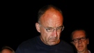 Douglas Garland is escorted into a Calgary police station in Calgary, Alta., Monday, July 14, 2014. (Jeff McIntosh/The Canadian Press)