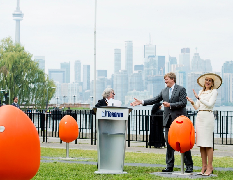 King Willem-Alexander, centre, and Queen Maxima of the Netherlands try out the new Tulpi chairs at a presentation on the Toronto Islands in Toronto on Friday, May 29, 2015. (Nathan Denette/THE CANADIAN PRESS)