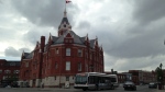 A bus rolls past Stratford City Hall on a gloomy day. (Abigail Bimman / CTV Kitchener)