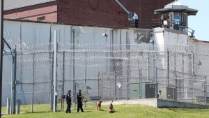 Law enforcement officers with bloodhounds stand guard at one of the entrances to the Clinton Correctional Facility in Dannemora, N.Y. on Saturday, June 6, 2015.  (Gabe Dickens/Press-Republican via AP)