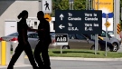Canadian border guards are silhouetted as they replace each other at an inspection booth at the Douglas border crossing on the Canada-USA border in Surrey, B.C., on August 20, 2009. (Darryl Dyck / The Canadian Press)