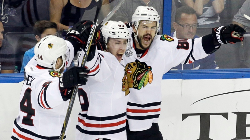 Chicago Blackhawks center Antoine Vermette (80) celebrates with left wing Teuvo Teravainen, center, and defenseman Kimmo Timonen after Vermette scored a goal against the Tampa Bay Lightning during the third period of Game 5 of the NHL hockey Stanley Cup Final, Saturday, June 13, 2015, in Tampa, Fla. (AP /John Raoux)
