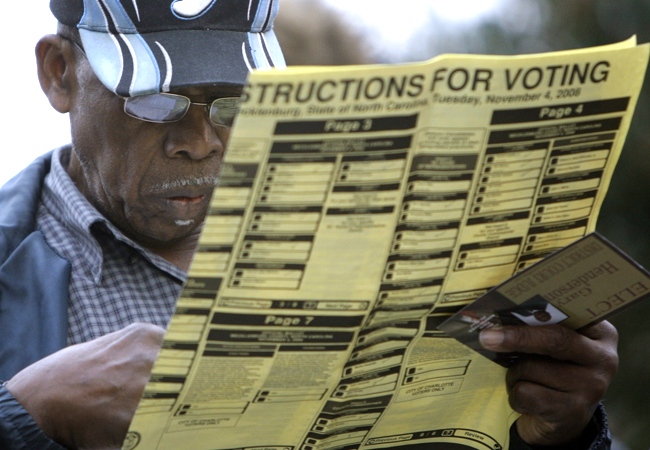 Roy Kilgo examines a voting ballot as he waits in line in Charlotte, N.C., Tuesday, Nov. 4, 2008. (AP / Chuck Burton)