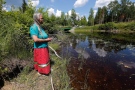 Community elder Grace Redsky from Shoal Lake 40 First Nation performed a water healing ceremony at a man-made channel made to support Winnipeg's water system which has cut them off from the mainland Thursday, June 25, 2015. (John Woods / THE CANADIAN PRESS)