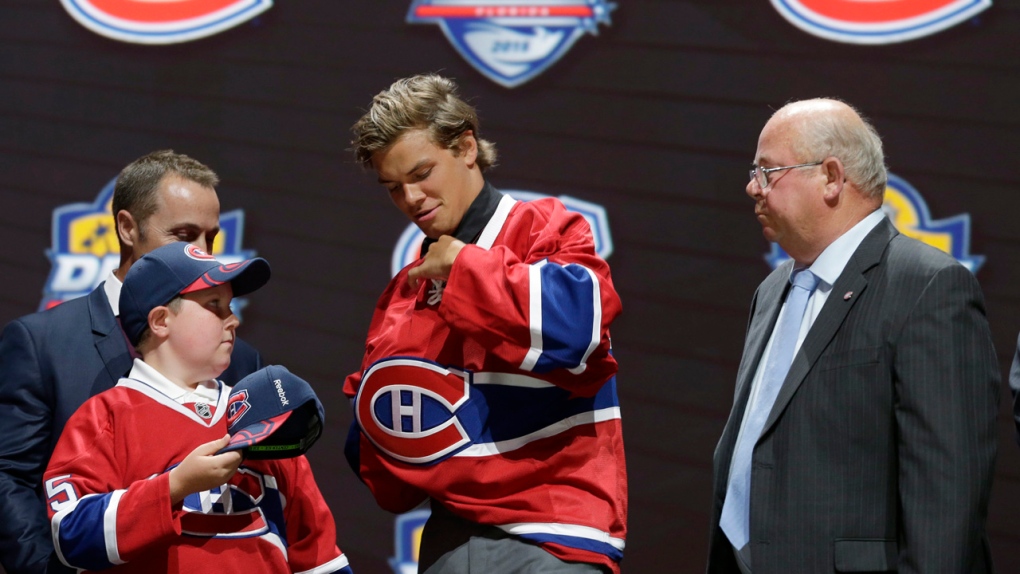 Noah Juulsen puts on a Montreal Canadiens sweater