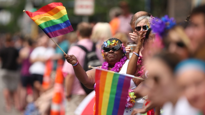 A woman waves a rainbow flag during the Gay Pride Parade in Minneapolis, Sunday, June 28, 2015. (Jeff Wheeler / Star Tribune)