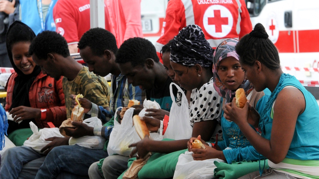 Migrants eat food in Italy