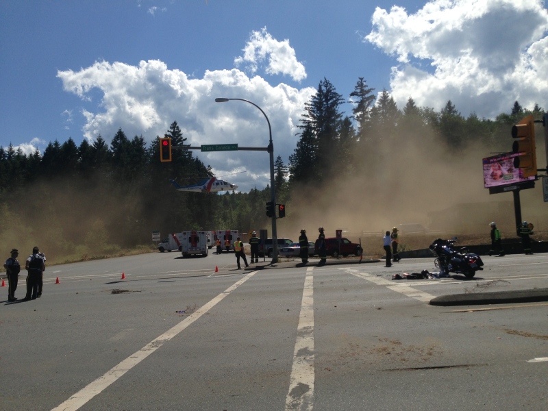 First responders can be seen near the site of a crash involving a motorcycle on Highway One just north of Ladysmith, B.C. June 30, 2015. (CTV Vancouver Island)