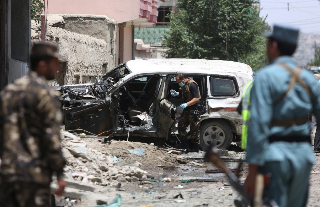 Afghan security personnel inspect bombed vehicle 