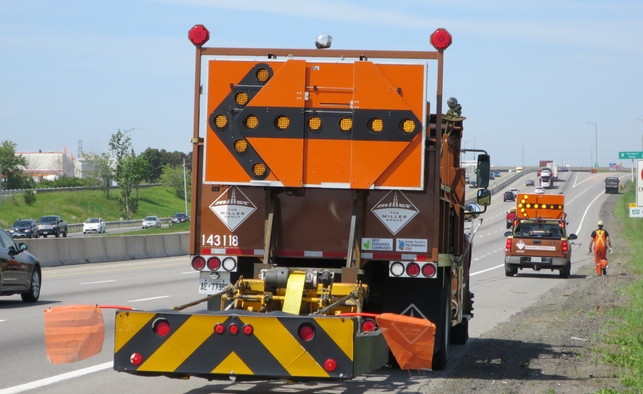 A crash truck diverts traffic so a worker can clean up tire debris (photo: Jil McIntosh)