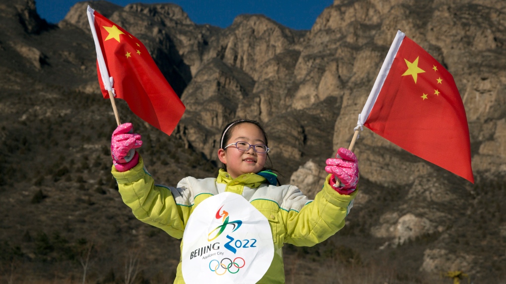Chinese girl waves flag wearing olympic bib
