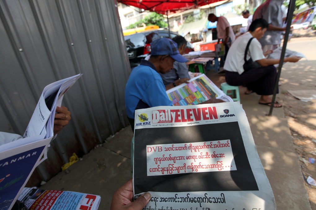Man reads newspaper in Yangon 