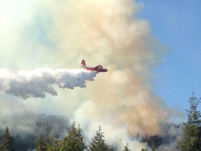 The massive Martin Mars water bomber soared above a wildfire that broke out at Cowichan Lake near Skutz Falls Tuesday, July 28, 2015. 