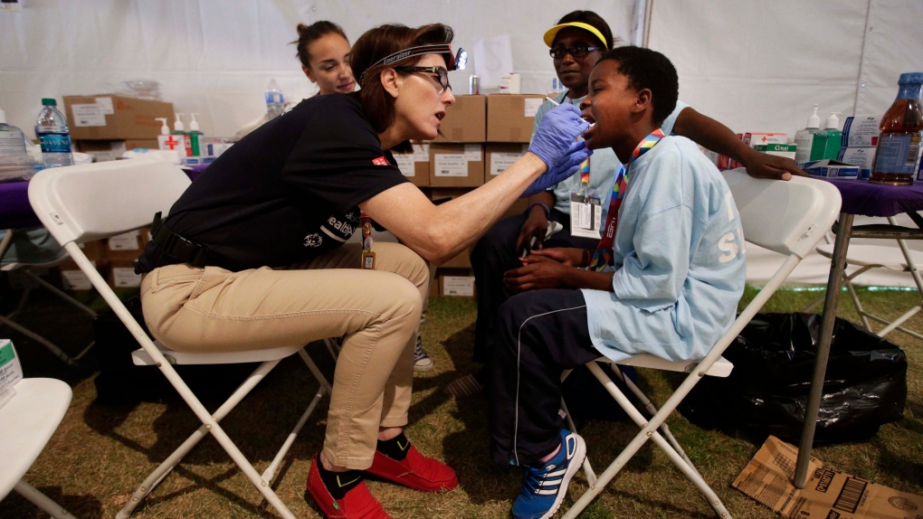 Volunteer examines athlete's teeth